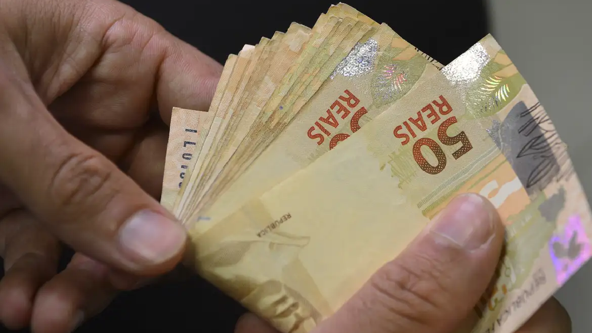Mão contando notas de 50 reais. Foto: Marcello Casal Jr/Agência Brasil