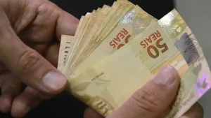 Mão contando notas de 50 reais. Foto: Marcello Casal Jr/Agência Brasil