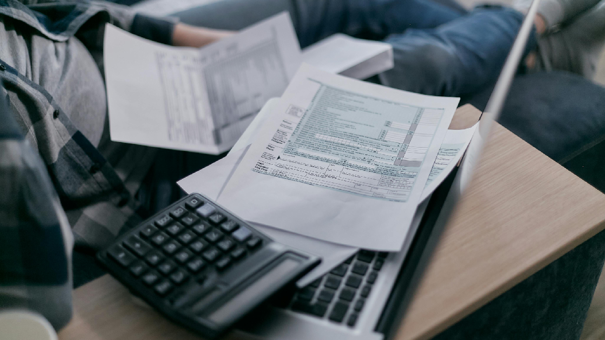 Notebook com papel de contas e uma calculadora em cima. Foto: Pexels
