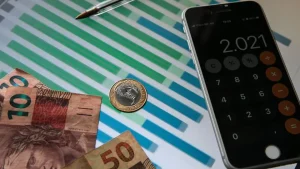 Mercado; Moedas e calculadora no celular. Foto: Marcello Casal Jr./Agência Brasil