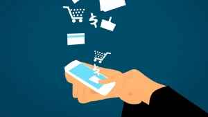 Arte com mão segurando celular e ícones de compras. Foto: PIxabay