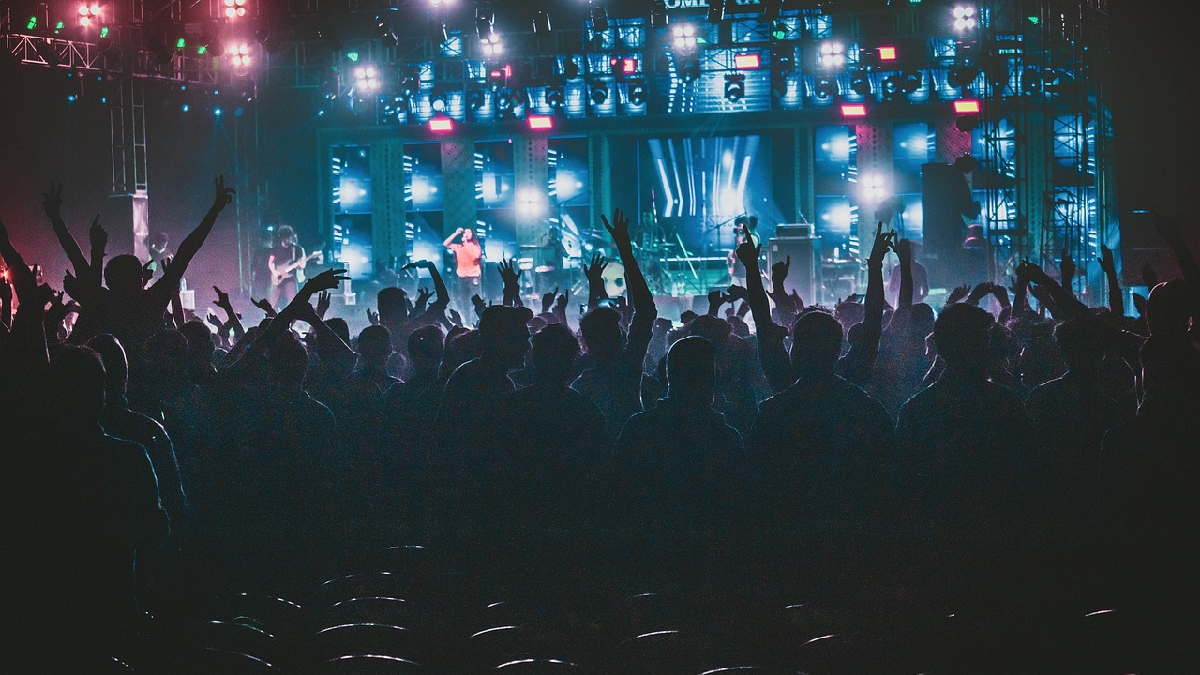 Pessoas em frente a um palco de show. Foto: Pixabay